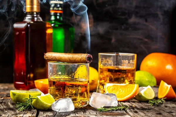 Whisky bebe en madera. Bebida de élite para la relajación masculina. whiskey, ron y cigarro, hielo sobre fondo de madera, espacio para copiar. concepto bebida de lujo — Foto de Stock
