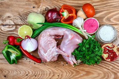 Ahşap bir arka plan üzerinde malzemelerle ham tavşan. üst görünüm. Diyet Beslenme Kavramı