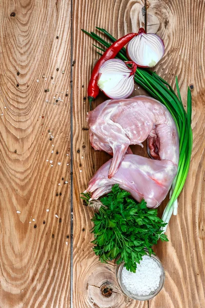 Ham tavşan otlar ve baharatlar ahşap bir arka plan üzerinde ızgara için hazır terbiyeli. üst görünüm. Diyet Beslenme Kavramı