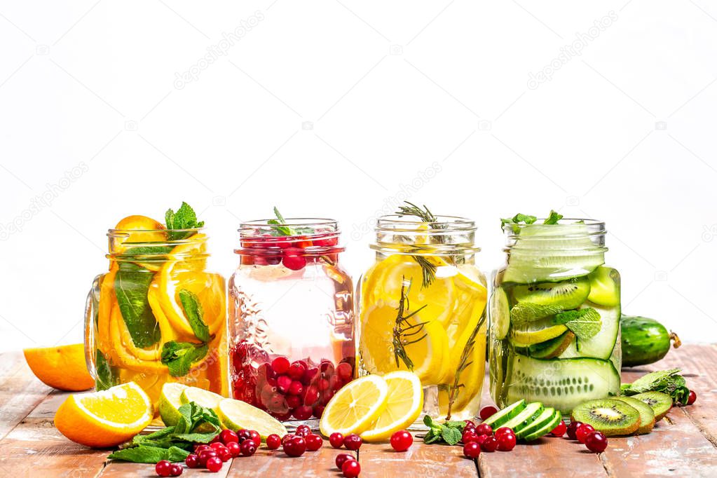 Infused water in bottles with various ingredients such as culinary aromatic herbs and fruits, healthy lifestyle concept. space for text
