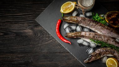 Plaka kesme tahta eski bir ahşap arka plan üzerinde çiğ taze nehir balığı. pişirmek için baharat ile balık. üst görünüm, metin için alan