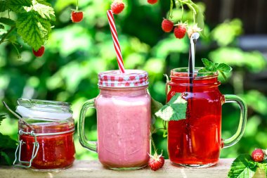 Reçel ve kompostolar Çeşitli Kavanozlar, bahçede ahududu ile yoğurt. metin için alan