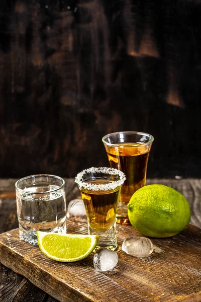 Concepto de bebida alcohólica. Tequila mexicano con lima y sal sobre fondo de madera rústica. espacio para el texto. concepto bebida de lujo — Foto de Stock