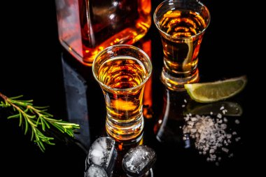 Siyah bir arka plan üzerinde kireç ve tuz ile Meksika Altın Tekila. Copyspace