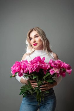 Güzel, şehvetli, çiçekli bir kızın portresi. Stüdyoda, karanlık bir arka planda.