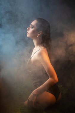Seksi ve seksi model kadın jakuzide oturuyor, su damlaları cesedin üzerine damlıyor. Stüdyo çekimi. Seçici odaklanma.