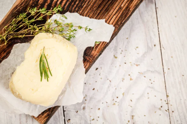 La mantequilla natural del granjero se hace casera. Bloque de mantequilla fresca en la tabla de cortar de madera. Vista superior. Espacio libre para tu texto — Foto de Stock