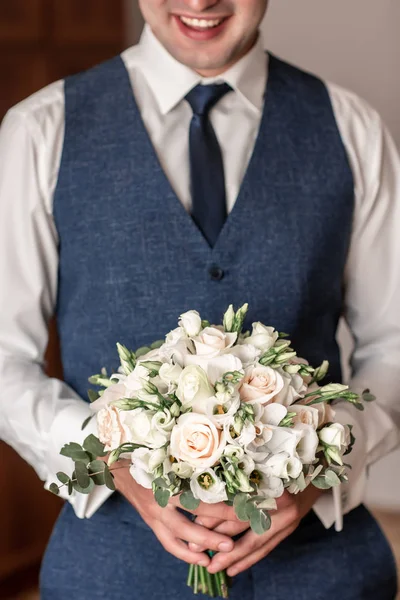 Ένας άντρας με μπλε κοστούμι που κρατάει ένα γαμήλιο μπουκέτο, ο γαμπρός με ένα μπουκέτο που περιμένει τη νύφη, ένας άντρας που κρατάει ένα μπουκέτο — Φωτογραφία Αρχείου