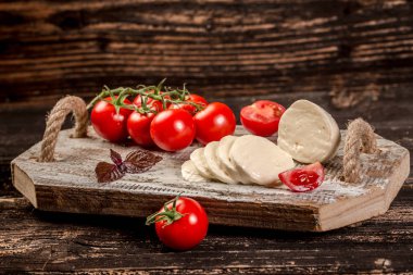 Mozzarella peyniri, fesleğen ve domates kirazı tahtada, kopyalama alanı. Caprese salatası için malzemeler. Metnin için boş yer