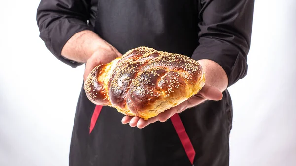 challah Jewish bread in man hands, homemade baking, traditional Jewish bread, Jewish pastries.