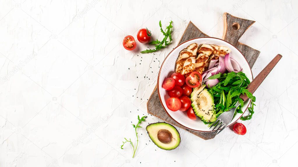 The concept of oriental cuisine. National Cyprus Salad with grilled Halloumi cheese, tomatoes, avocado, arugula on a light background, top view.