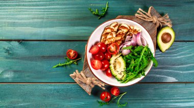 Izgara Halloumi peyniri, domates, avokado, roka ve susamlı Buda kasesi. Detoks ve sağlıklı yiyecek kasesi konsepti. Yukarıdan, yukarıdan, dümdüz..