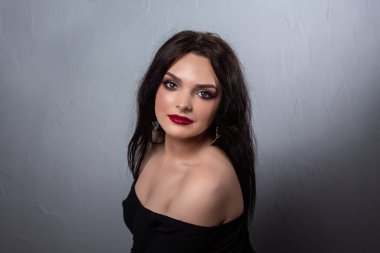 Stüdyoda karanlık arka planda makyaj yapmış güzel bir genç kız. Güzel kaplıca mankeni kız cilt bakımı.