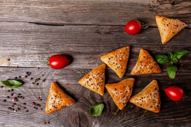 Samsa or samosas with meat and vegetables on rustic background, top view. Traditional Indian food. Copy text.
