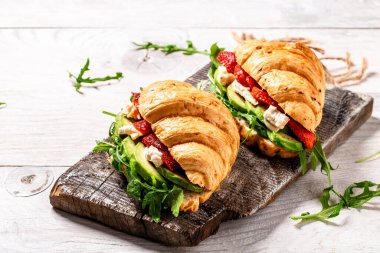 Lezzetli kahvaltıda tam tahıllı kruvasan sandviç, çilek, roka, avokado ve peynir, camembert peyniri..