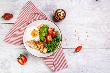 Keto diyet yiyecekli tabak roka ve çilekli tavuk salatası. Üst görünüm.