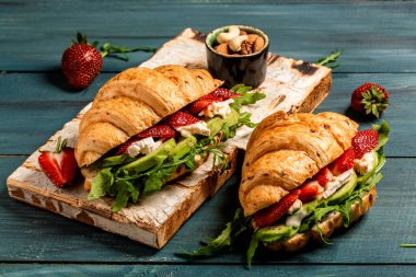 Çilekli ve aragüllü kruvasan sandviçi. Lezzetli kahvaltı ya da atıştırmalık. en üstteki görünüm.