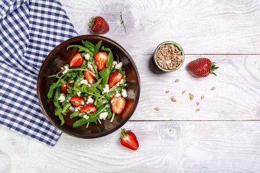 Arugula ve ricotta ile çilek salatası, beyaz ahşap arka plan, uzun pankart, üst görünüm.