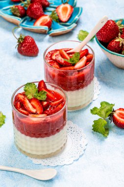 Çilekli panna cotta, açık arkaplanda, yukarıdan görünüm.