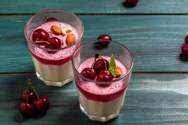 Ahşap arka planda cam kavanozlarda kirazlı meyveli tatlı. Geleneksel İtalyan tatlısı.