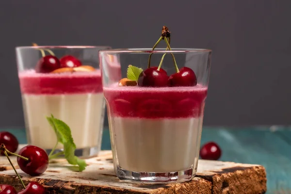 Classic italian dessert panna cotta with cherry sauce on rustic background. Fruit dessert with cherry.