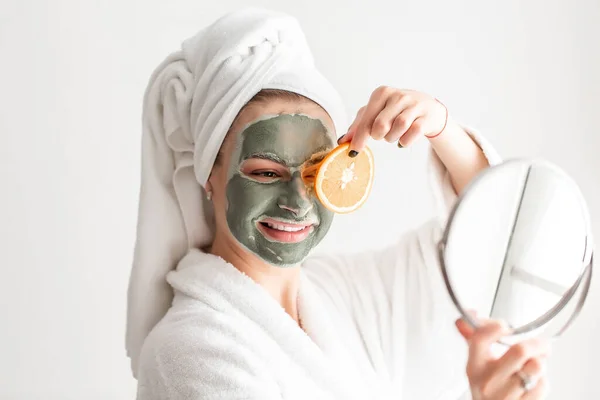 Wanita Potret Dengan Masker Wajah Wajahnya Memegang Irisan Jeruk Segar — Stok Foto