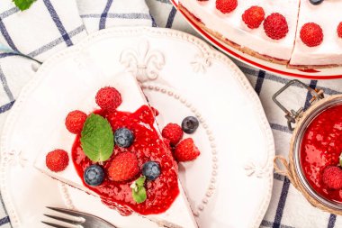Vegan çiğ ahududulu peynirli kek. Taze böğürtlen ve naneyle süslenmiş. Sağlıklı vejetaryen gıda konsepti. Şeker, süt ürünü ve glütensiz tatlı..