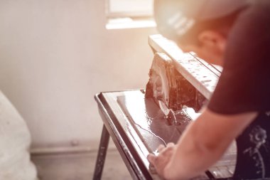Yakın çekim işçisi mermer taş kesmek için ıslak testere makinesi kullanıyor. İşi bitirmek için bir araç. Su kesme makinesiyle seramik fayans kesme.