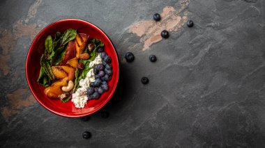 Karamelli şeftalili lahana salatası, yabanmersini ve keçi peyniri, ahşap arka plan. Uzun pankart biçimi, üst görünüm.