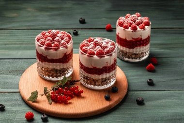 Raspberry dessert, cheesecake, trifle, mouse in a glass on a wooden background. sweet raspberry dessert. clipart