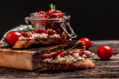 Ahşap zemin üzerinde güneşte kurutulmuş domates ve ricotta diyet peyniri..