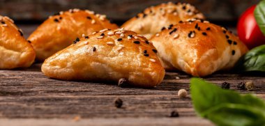 Samosalar, Özbek mutfağı, Orta Asya mutfağı. Tavuklu samsa, susam tohumlu samosa, tahta tahtada samosa, uzun pankart formatında. Metin için boşluk.