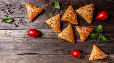 Asya yemekleri. Tahta bir arka planda domatesli vejetaryen samsa samosas fotokopi alanı üst görünümü.