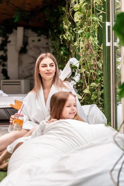 Family time, spa and beauty, mothers day. mom and daughter in beautiful spa with big garden view window. Kids hygiene.