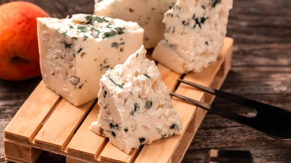 Dorblu cheese, Danish blue cheese on wooden background. Food recipe background. Close up.