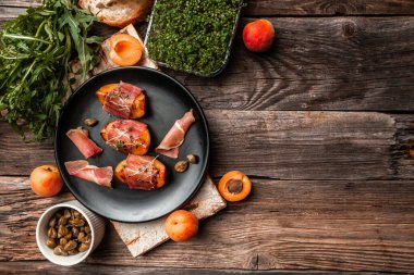 Lezzetli ve sağlıklı ızgara şeftali, prosciutto, kapari, mikroyeşil, yemek konsepti. Kopyalama alanı olan uzun biçim,