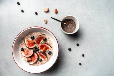 Beyaz yulaf, incir, yaban mersini ve chia çekirdeği. Sağlıklı yulaf ezmeli kahvaltı. Spor yemeği. Düzgün beslenme. Düz yatıyordu. Üst görünüm.