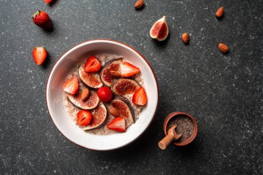 Sağlıklı kahvaltı, meyveli yulaf ezmesi, incir, çilek ve chia çekirdeği, tatlım. Glütensiz, laktozsuz, düz uzanmış.