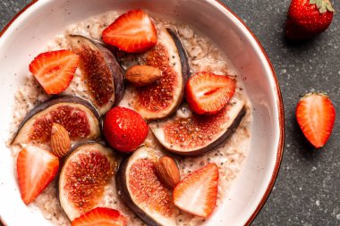 Kırmızı incirli yulaf ezmesi, çilek. Chia tohumları, kasede ceviz, kilo vermek için yiyecek. Yukarıdan görüntüle.