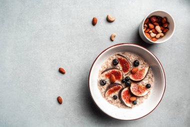 İncirli yulaf ezmesi, yaban mersini ve fındık. Sonbahar yemeği konsepti. Pankart, yemek servisi menü tarifi yeri, metin, üst görünüm.