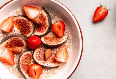 İncirli yulaf ezmesi, çilek, chia tohumu ve fındık. sağlıklı kahvaltı.