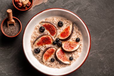 Sağlıklı bir kahvaltı için gereken malzemeler yulaf ezmesi, yaban mersini, incir, chia tohumu ve fındık, sağlıklı kahvaltı glüten, laktozsuz, fitness yiyeceği..
