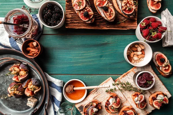 İncirli bruschetta seti ve keçi peyniri, böğürtlen, fındık, bal. Kızarmış ekmekli crostini, mavi peynir, soğan reçeli. Pankart, yemek servisi menü tarifi yeri, metin, üst görünüm.