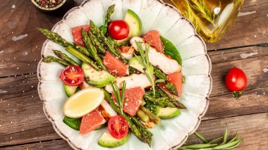 Tavuklu sağlıklı salata, avokado, kuşkonmaz, domates soslu kahvaltı veya atıştırmalık. Üst Manzara. Düz uzanın, başınızın üstünde.