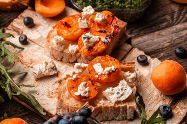 Vejetaryen yemeği. Kızarmış şeftalili sandviçler, mavi peynir, yabanmersini ve bal, ahşap arka plan, şeftalili ciabatta, üst manzara..