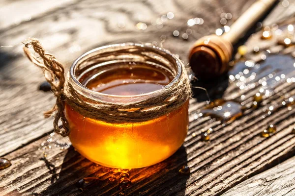 香り高い蜂蜜を木のテーブルの上の瓶に ミツバチの製品は有機天然成分の概念によるもので — ストック写真