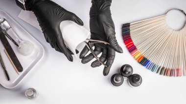 Beyaz arka planda sterilize edilmiş aletler. İlaç ya da güzellik salonu. Kapatın. Eller manikür işleminden önce el işi zarfından manikür aletlerini alıyor..
