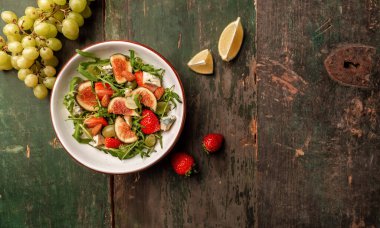 Rozetli vejetaryen salatası, incir, mavi peynir, çilek, üzüm, uzun pankart formatı. Metin için boşluk.