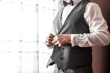 Damat sabah hazırlığı, yakışıklı damat giyiniyor ve düğüne hazırlanıyor, beyaz gömlekli. Damat sabah hazırlığı. Genç damat düğün gömleği giyiyor..