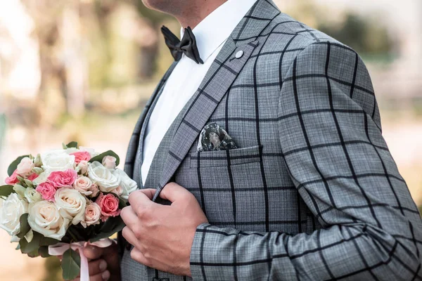 新郎の朝の準備 ハンサムな新郎は服を着て結婚式の準備 ブローチ付きのセルで灰色のスーツで — ストック写真